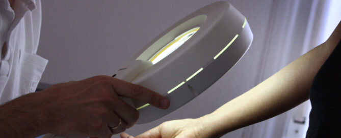 Bei der Hautkrebs-Früherkennung wird beim Dermatologen mit einem Vergrößerungsglas die Haut nach Veränderungen abgesucht.